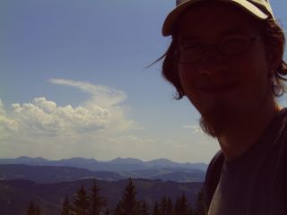 Christian auf dem Turm vor Alpenpanorama