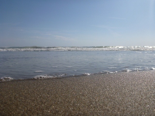 Wellenfilm auf dem Sandstrand